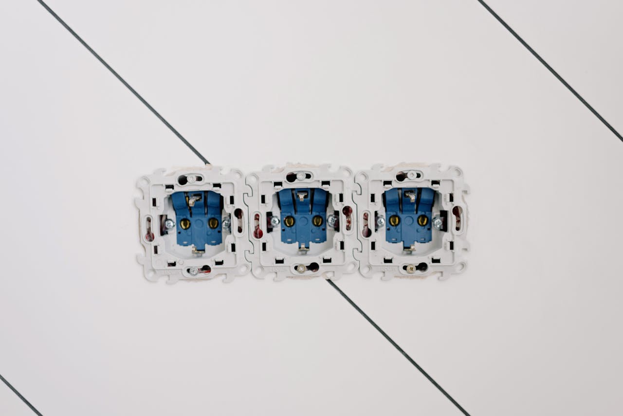 about-us Power sockets with various connectors and bolts on wall in room at home